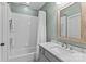 Fresh bathroom features a shower-tub combination with a decorative framed mirror above the sink at 129 Alder Springs Ln, Mooresville, NC 28117