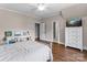Bedroom features hardwood floors, a bed with white bedding and white trim at 129 Alder Springs Ln, Mooresville, NC 28117