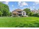 Expansive green lawn and rear exterior of home featuring large windows and outdoor entertaining spaces at 129 Alder Springs Ln, Mooresville, NC 28117