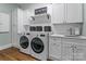 Well-appointed laundry room with washer, dryer, and custom cabinetry at 129 Alder Springs Ln, Mooresville, NC 28117