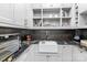 Butler's pantry featuring black granite countertops, white cabinetry, and open shelving at 129 Alder Springs Ln, Mooresville, NC 28117