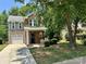Attractive brick and stone home with a green roof, showcasing a neat front yard and mature tree at 13913 Pinyon Pine Ln, Charlotte, NC 28215