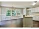 Bright kitchen with white cabinets, a functional island, and dining area featuring ample windows at 13913 Pinyon Pine Ln, Charlotte, NC 28215