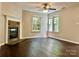 Spacious living room with a fireplace, wood floors, and lots of natural light from surrounding windows at 13913 Pinyon Pine Ln, Charlotte, NC 28215