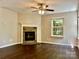 Cozy living room with a stone fireplace, wood flooring, and a bright window view at 13913 Pinyon Pine Ln, Charlotte, NC 28215