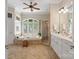 Bright bathroom features large soaking tub, walk-in shower, white cabinets and neutral tile at 14515 Nolen Ln, Charlotte, NC 28277