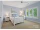 Bedroom with a white bed, nightstand, and a window letting in natural light at 14515 Nolen Ln, Charlotte, NC 28277