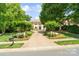 Charming home featuring a brick driveway surrounded by lush greenery and mature trees at 14515 Nolen Ln, Charlotte, NC 28277