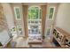 Bright living room with a stone fireplace, tall windows, and access to a deck at 14515 Nolen Ln, Charlotte, NC 28277