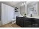 Modern bathroom with double vanity, shower, and decorative shelving at 15639 Sir Charles Pl, Charlotte, NC 28277