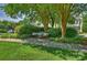 Peaceful common area showcasing manicured landscaping and a tranquil bench under mature trees at 15639 Sir Charles Pl, Charlotte, NC 28277