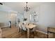 Dining room featuring hard wood floors, dining table, chandelier and view to kitchen and staircase at 15639 Sir Charles Pl, Charlotte, NC 28277