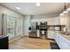 Bright kitchen with stainless steel appliances, white cabinets, and a view to the yard at 15639 Sir Charles Pl, Charlotte, NC 28277