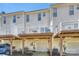 Rear townhouse exterior with decks on each level and garages below, offering outdoor living at 15639 Sir Charles Pl, Charlotte, NC 28277