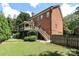 Brick home featuring a screened deck, a putting green, and a well-maintained lawn with mature trees at 1638 Myers Park Dr, Charlotte, NC 28207