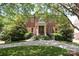 Stately brick home with mature trees and a well-manicured lawn offers timeless curb appeal at 1638 Myers Park Dr, Charlotte, NC 28207