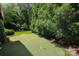 Backyard putting green surrounded by mature landscaping, offering a private and recreational space at 1638 Myers Park Dr, Charlotte, NC 28207