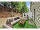 Backyard with white fence, faux turf, pea gravel, seating, and small outdoor table at 1915 Travertine Ln, Fort Mill, SC 29708