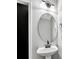 Stylish bathroom features a pedestal sink, a round mirror, and black fixtures at 1915 Travertine Ln, Fort Mill, SC 29708