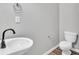 Modern bathroom featuring a toilet, a sink with black faucet, and gray walls at 1915 Travertine Ln, Fort Mill, SC 29708