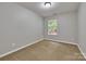 Simple bedroom with neutral carpet, a window view, and a calming color scheme at 1915 Travertine Ln, Fort Mill, SC 29708