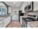 Modern kitchen boasts stainless steel appliances, granite countertops, and white cabinetry at 1915 Travertine Ln, Fort Mill, SC 29708