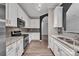 Modern kitchen featuring gray backsplash, white cabinets, and stainless steel appliances at 1915 Travertine Ln, Fort Mill, SC 29708
