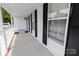 View of the covered front porch featuring a concrete floor, white railing, and black shutters at 2008 Bantry Ln, Charlotte, NC 28262