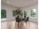Bright dining area featuring a glass table, four chairs, hardwood floors, and multiple windows overlooking greenery at 207 9Th Ne Ct, Conover, NC 28613