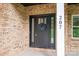 Close up of the front door with a wreath, brick facade, and white pillar with the house number at 207 9Th Ne Ct, Conover, NC 28613