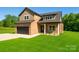 Charming two-story home with brick and siding, black garage door and a well-manicured lawn at 207 9Th Ne Ct, Conover, NC 28613