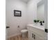 Clean half bathroom features a white vanity with black hardware and a decorative picture on the wall at 207 9Th Ne Ct, Conover, NC 28613