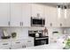 Close-up of modern kitchen with white cabinets, stainless steel appliances, quartz countertops, and pendant lighting at 207 9Th Ne Ct, Conover, NC 28613