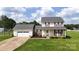 Charming two-story home featuring a well-manicured lawn, attached garage, and a welcoming front porch with rocking chairs at 2377 Mintew Cir, Lincolnton, NC 28092