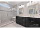 Bright bathroom featuring double vanity, modern sinks, and glass-enclosed shower with bench at 310 N Dotger N Ave # 4, Charlotte, NC 28204