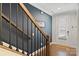 Elegant stairway with wooden railing and navy walls leading to the front door at 310 N Dotger N Ave # 4, Charlotte, NC 28204