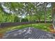 Spacious backyard featuring a wooden deck with bench seating, lush grass, and mature trees for privacy at 3163 Maury St, Charlotte, NC 28208