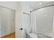 Clean bathroom featuring a white subway tile shower, a white toilet and a door leading to another room at 3163 Maury St, Charlotte, NC 28208