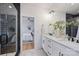 Modern bathroom featuring a double vanity with white cabinets and a glass shower with black subway tile at 3163 Maury St, Charlotte, NC 28208