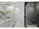 Modern bathroom featuring a double vanity with white cabinets and a glass shower with black subway tile at 3163 Maury St, Charlotte, NC 28208