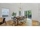 Elegant dining room with a modern table, stylish chairs, hardwood floors, and sliding glass doors to the backyard at 3163 Maury St, Charlotte, NC 28208