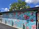 Whimsical Bossy mural on building exterior with floral design at 3163 Maury St, Charlotte, NC 28208