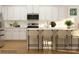 Bright kitchen boasts white cabinets, stainless steel appliances, and island with seating at 3882 Horsham St, Indian Land, SC 29707