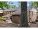Cozy backyard with brick exterior, patio seating area, and mature tree at 3900 Langley Rd, Charlotte, NC 28215