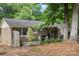 This backyard features a patio with an outdoor dining area and mature trees at 3900 Langley Rd, Charlotte, NC 28215