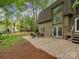 Scenic backyard with a brick patio and comfortable seating area under mature trees at 4025 Woodfox Dr, Charlotte, NC 28277