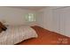 Bedroom with hardwood floors, window with shutters, and double closets at 4025 Woodfox Dr, Charlotte, NC 28277