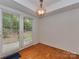 Bright dining area featuring hardwood floors, a modern chandelier, and large windows overlooking the yard at 4025 Woodfox Dr, Charlotte, NC 28277