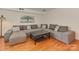 Spacious living room with hardwood floors, gray sectional, and modern decor at 4025 Woodfox Dr, Charlotte, NC 28277