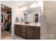 Well-lit bathroom with double vanity, walk-in closet, and glass-enclosed shower at 4117 Galloway Park Dr, Charlotte, NC 28262